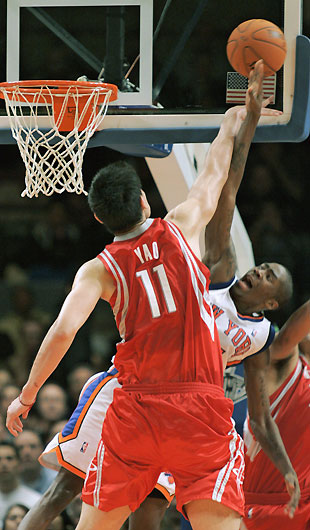Houston Rockets center Yao Ming (C) pass over New York Knicks guard Nate Robinson (4) and center Eddie Curry in the second period of their NBA basketball game in New York, November 20, 2006. The pass was intercepted by the Knicks Jamal Crawford.