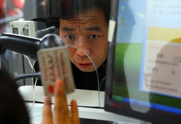 A worker at Beijing Railway Station checks a passenger's ID and ticket as the Spring Festival travel season commenced on Sunday. Zou Hong/China Daily Nationwide rush for home kicks off