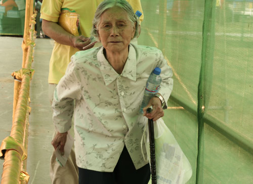 An aged woman waits to cast a vote on the demolishment and reconstruction of old buildings in Juixiaqiao Sub-district in Beijing, June 9, 2007. Local government and the real estate developer jointly organize the vote on Saturday to see if majority residents of over 5000 families accept the new compensation policy after failed attempts to reach an agreement through other ways. Both notary officials and supervisors are invited to monitor the vote that runs from 9 a.m. to 9 p.m. at six ballot booths. [Sun Yuqing/m.ming7.cn]