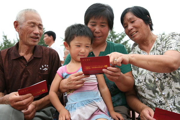 Villagers get pension deposit books under a new elderly insurance system for rural residents in Shouguang city, Shandong province on Aug 19, 2009. China's rural achievements in the past decade