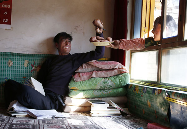 For rural poet Kang Pengfei, baked potatoes provide food for thought. Kuang Linhua / China Daily Farmers harvest a crop of poetry