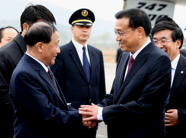Vice-Premier Li Keqiang is greeted by his Democratic People's Republic of Korea counterpart Kang Sok-ju at Pyongyang airport on Sunday as he starts a three-day visit to the country. Pledge to play major role for Korean peace
