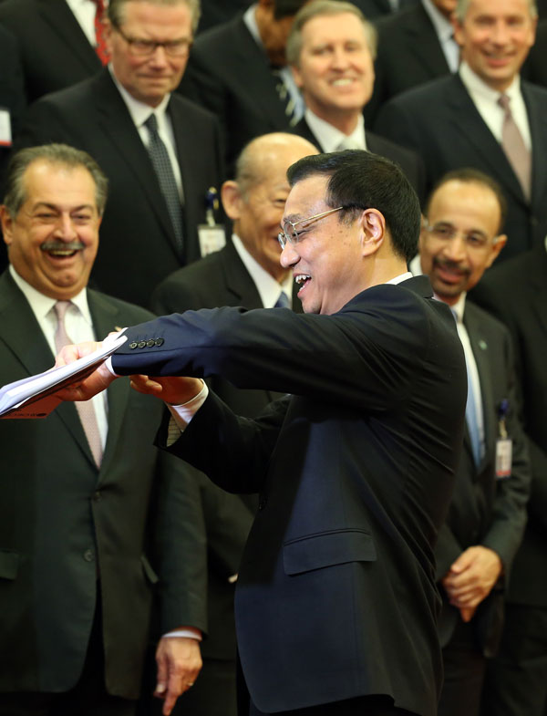 Premier Li Keqiang explains his late arrival to a meeting of business leaders of major companies who attended the China Development Forum on Monday at the Great Hall of the People in Beijing. wu zhiyi / china daily Li focuses on consumption