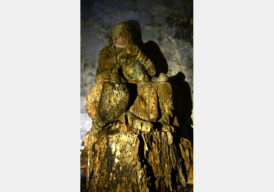Wood sculptures discovered inside cliffside cave in Chongqing