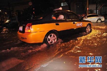 京城暴雨捧紅“POSE哥”：把雨當海 把車當船(圖)