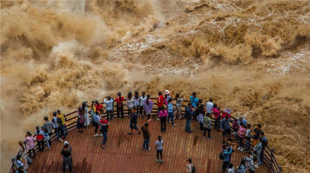 游客近距離觀賞虎跳峽“超級(jí)山洪” 近在咫尺大呼過癮