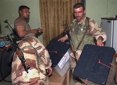 Iraqi soldiers carry ballot boxes at the end of the voting day, in Baqouba, Iraq, Saturday Oct. 15 2005
