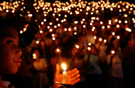 An Indonesian Christian holds a candle during Christmas mass at a stadium in Jakarta December 24, 2006. Jakarta is deploying about 18,000 police and 2,000 soldiers across the capital and its outskirts ahead of Christmas, a senior official said.
