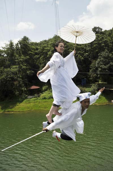 At Wild Duck Lake resort in Kunming, Yunnan province, employees demonstrate kung fu fighting over water, using wires, Aug 19, 2013. Visitors can be kung fu fighters at Yunnan resort