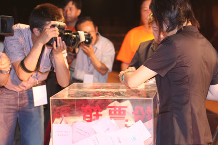 Photographers take the picture as two notary officials seal the balloting boxes after a voting on the housing demolition and compensation policy at Jiuxianqiao sub-district in Chaoyang District of Beijing, June 9, 2007. Some 3,711 families, about 57% of the 5,473 families, cast their votes on Saturday, with 2,451 votes for and 1,228 votes against the demolition and compensation plan. Thirty-two votes were invalid. [Sun Yuqing/m.ming7.cn]