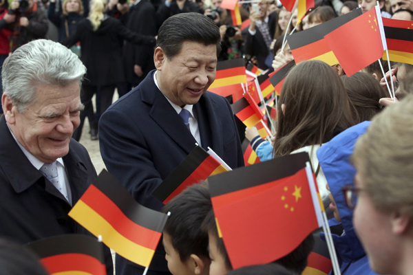 German President Joachim Gauck and President Xi Jinping greet students after a military welcome ceremony prior to a meeting at the Bellevue Palace in Berlin on Friday. PHOTO BY MICHAEL SOHN / AP Xi refutes fears over China's national defense buildup