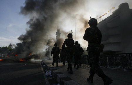 Thai troops surround protestors after 2 killed in clash