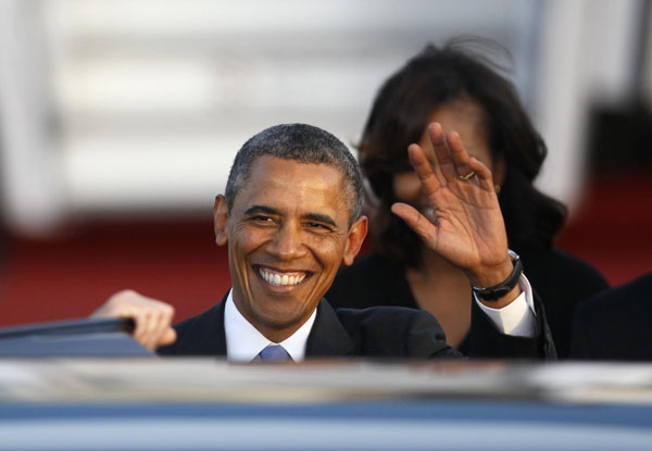 US President Barack Obama waves as he arrives with his wife Michelle (right) at Tegel airport in Berlin June 18, 2013.[ US surveillance to overshadow Obama's Berlin trip