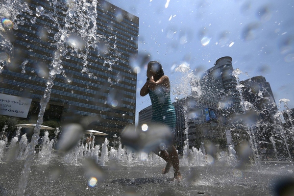 Girl plays at fountain to cool down in Seoul